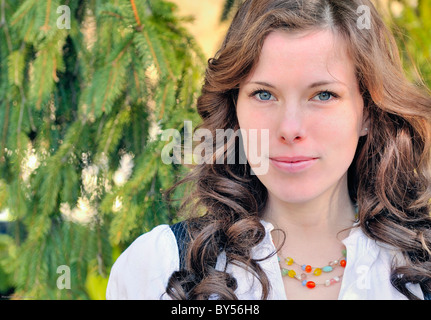 Close-up de belle jeune femme brune yeux bleu 20s outdoor caméra portrait cheveux bouclés pas de questions sensibles Banque D'Images