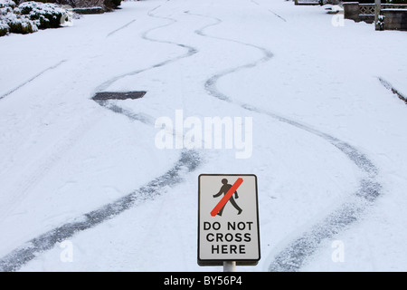 Marques de dérapage dans la neige, d'une voiture sur une route escarpée à Ambleside UK Banque D'Images