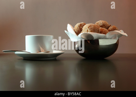 Un bol de trous de beignes et une tasse de café Banque D'Images