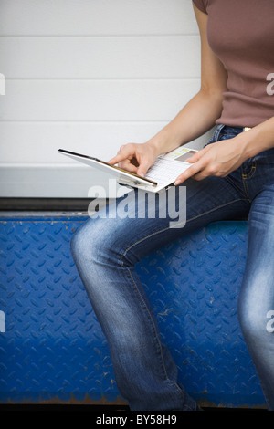 Woman on ledge with laptop Banque D'Images
