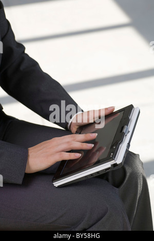 Woman holding tablet PC sur lap Banque D'Images