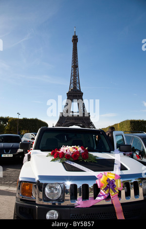 Une voiture décorée de fleurs et de rubans en face de la Tour Eiffel Banque D'Images