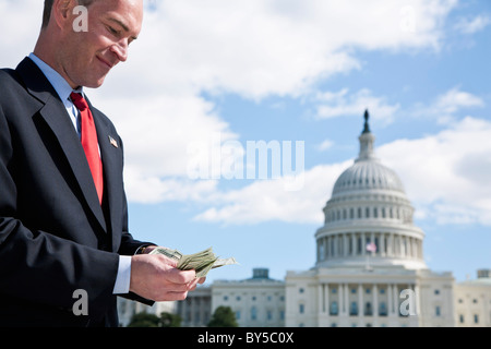 Un homme politique de l'argent comptant en face de l'US Capitol Building Banque D'Images