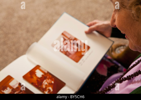 A senior woman looking at un album photo Banque D'Images