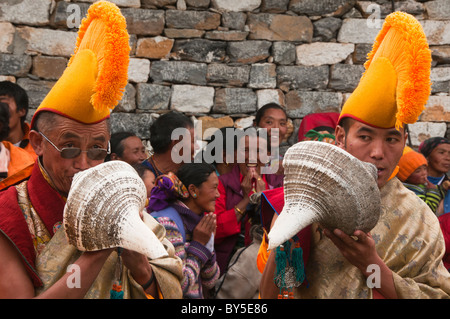 Les moines Gelugpa chapeau jaune soufflé conques au festival Mani Rimdu à Tengboche monastère dans la région de l'Everest Népal Banque D'Images