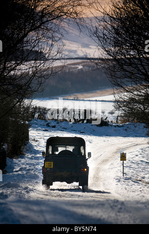 Une landrover conduisant le long d'un pays couvert de neige 'B' road in rural North Dorset. Banque D'Images