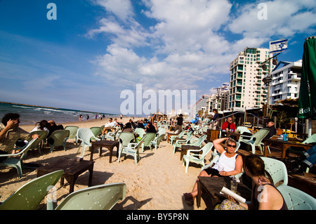 Profiter de la belle plage bondée à Tel Aviv lors d'une journée d'hiver ensoleillée étouffant. Banque D'Images