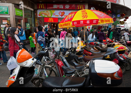 Les gens de l'extérieur des cycles et une succursale de hamburger de McDonald's restaurant fast food à Chengdu, province du Sichuan, Chine. JMH4341 Banque D'Images