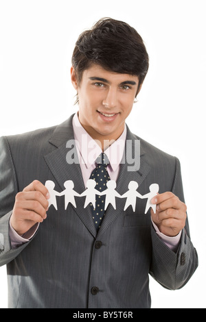 Portrait of smiling businessman holding personnes découper du papier Banque D'Images