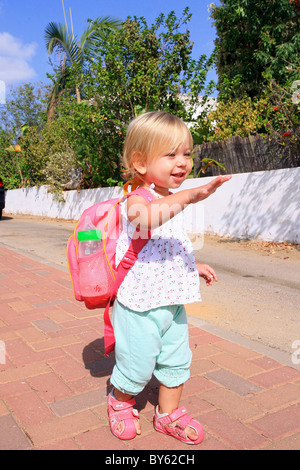 Un Bebe Fille De 18 Mois Avec Un Petit Lunch Pack Avec Bouteille Prete Pour La Maternelle Forme Bye Bye Photo Stock Alamy