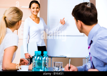 Portrait de femme d'affaires démontrant quelque chose sur le tableau blanc au séminaire Banque D'Images