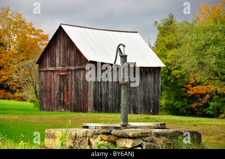 Une vieille pompe à eau et petite grange dans le Nord de New York. Banque D'Images