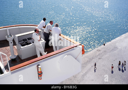 Le capitaine de navire de croisière et les officiers sur l'aile avec les pilotes de port en attente de départ sur les personnes ci-dessous à quai du port de Naples Italie Banque D'Images