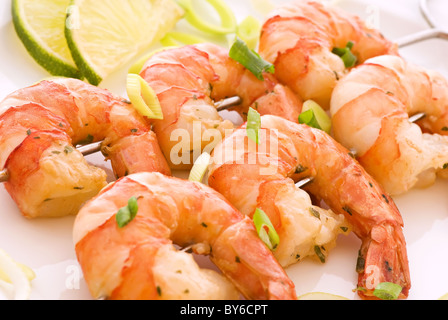 Brochette de crevettes avec des langoustines et le poireau en gros plan sur une plaque blanche Banque D'Images