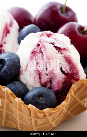 Boule de crème glacée avec fruits frais comme libre dans un bol gaufré Banque D'Images