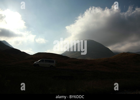 Une scène de montagne spectaculaire de la région des Highlands de l'Écosse, avec un camping-car-van voyageant sur la route A82. Banque D'Images