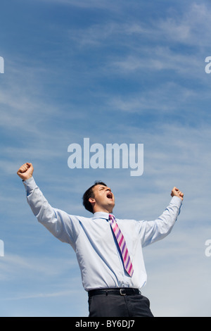 Portrait de jeune homme heureux avec ses bras levés vers le ciel et crier Banque D'Images