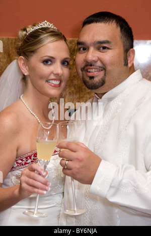 Bride and Groom touch champagne verres remplis pour chaque autre jour de leur mariage à la réception. Banque D'Images