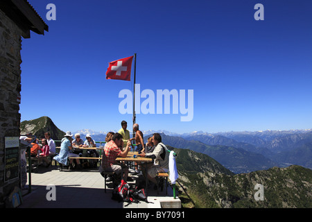 Les randonneurs se reposer en face de la montagne à Capanna Tamaro hut, randonnée Randonnée au Monte Tamaro, Tessin, Suisse Banque D'Images