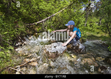 Girl (10-11 ans) près de la rivière Isar, Hinterau source Vallée, gamme de Karwendel, Tyrol, Autriche Banque D'Images