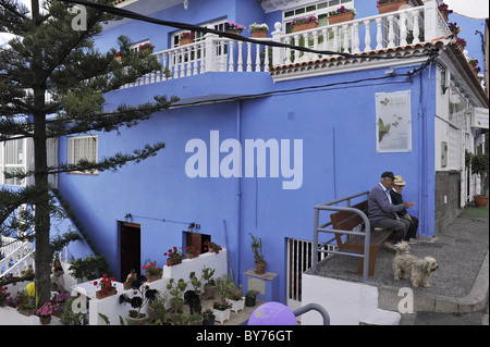 Deux hommes âgés sur un banc en face d'une maison bleue, El Sauzal, Casa del Vino, Tenerife, Canaries, Espagne Banque D'Images