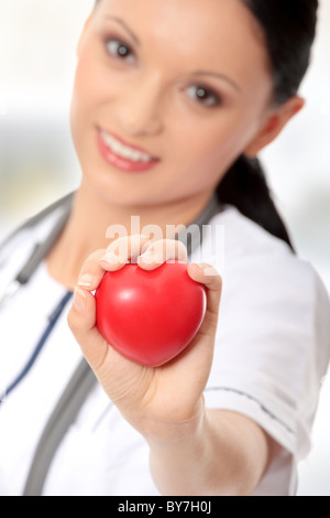 Femme médecin avec sthetoscope holding heart Banque D'Images