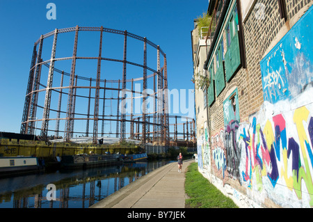 Jogger le long de Regents Canal chemin de halage près de Orchard Londres Hackney gasworks par Columbia Road Market. Graffiti sur mur. Banque D'Images