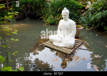 Bouddha en pierre blanche flottant sur une plate-forme en Andre Heller Botanical Gardens Gardone Riviera Lac de Garde Italie Banque D'Images