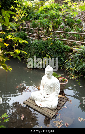 Bouddha en pierre blanche flottant sur une plate-forme en Andre Heller Botanical Gardens Gardone Riviera Lac de Garde Italie Banque D'Images