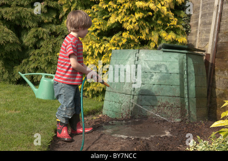 Garçon jouant avec le soutien de faire une flaque d'eau et de boue dans le jardin arrière. quatre-année-vieux Banque D'Images