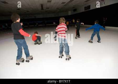 Roller enfants l'obscurité dans une patinoire, United States Banque D'Images