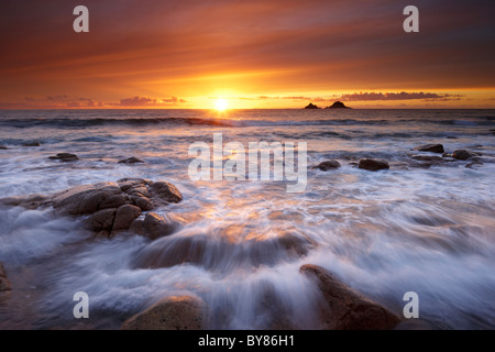 Lumière magique brille au-dessus du rivage baignant la côte de Cornouailles avec une lueur dorée. Banque D'Images