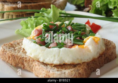 Oeufs au plat avec le jambon sur pain grillé et salade Banque D'Images