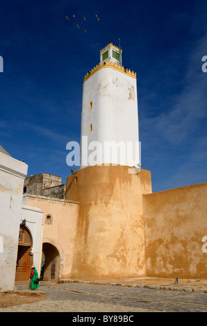 Minaret de la Grande Mosquée de cour avec une vieille dame en vert et bleu ciel en vieille ville portugaise d'El Jadida Maroc Banque D'Images