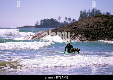 Long Beach, réserve de parc national Pacific Rim, côte ouest de l'île de Vancouver, C.-B. Colombie-Britannique Canada, surfeur surf avec chien Banque D'Images