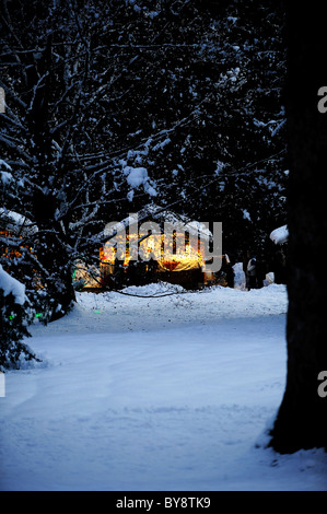 Maisons aux fenêtres éclairées dans la neige Banque D'Images