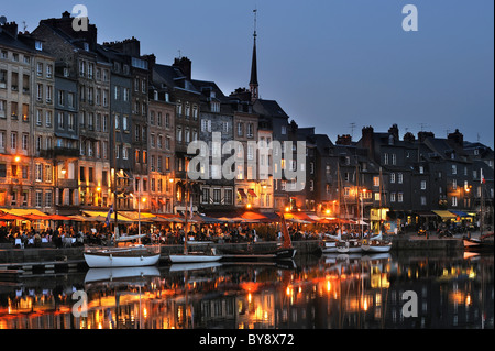 Bateaux à voile et les touristes à cafés / terrasses de cafés le long du quai de la nuit du port de Honfleur, Normandie, France Banque D'Images