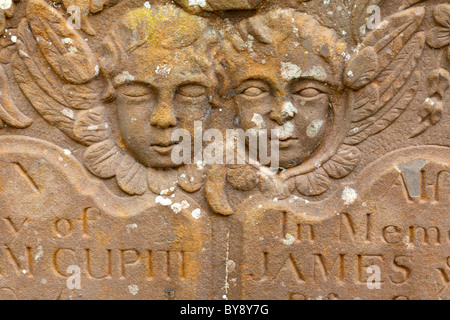 Deux chérubins (un œil ouvert, l'un les yeux fermés) sur une pierre tombale dans le cimetière à l'Awre, Gloucestershire Banque D'Images