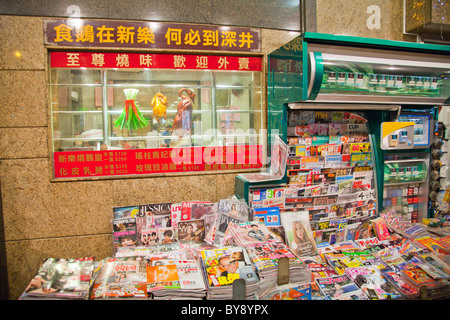 News stand typique de l'île de Hong Kong, Papiers & magazines partout, outsaide - magasin vendant le canard de Pékin Banque D'Images