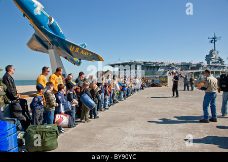 Boy & Louveteaux avec les dirigeants en attendant l'embarquement USS Lexington Banque D'Images