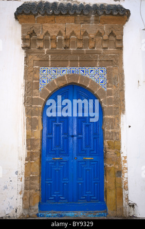 Peint bleu frais porte avec pierres apparentes et carrelage dans le bâtiment blanc sur Essaouira Medina Banque D'Images