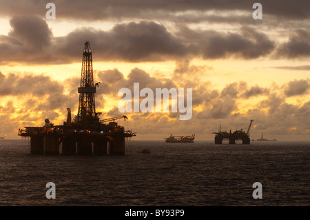Plates-formes pétrolières et des navires dans le bassin de Campos, l'état de Rio de Janeiro, Brésil, pendant l'heure du coucher du soleil. 2011 Banque D'Images