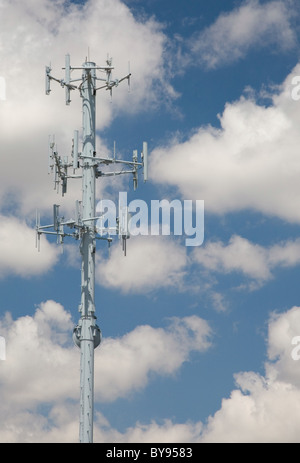 La tour de télécommunications cellulaires contre un ciel bleu nuageux. Banque D'Images