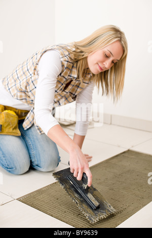 Amélioration de l'habitat, de rénovation - handywoman installent des tuyaux, truelle de mortier Banque D'Images