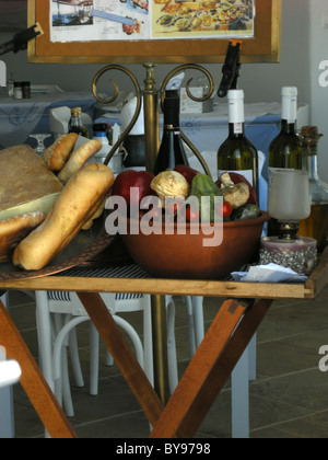 Bouteilles de vin & alimentation affichée sur une table dans un restaurant sur l'île grecque de Santorin dans la mer Égée Banque D'Images