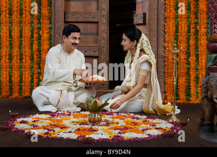 South Indian couple avec une fleur rangoli Banque D'Images