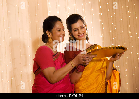 Mère et fille avec un plateau de diyas Banque D'Images