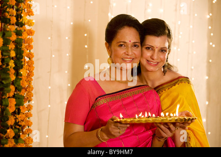 Mère et fille holding a tray de diyas Banque D'Images