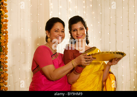 Mère et fille holding a tray de diyas Banque D'Images