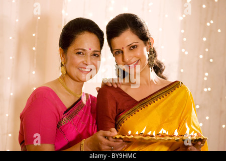 Mère et fille holding a tray de diyas Banque D'Images